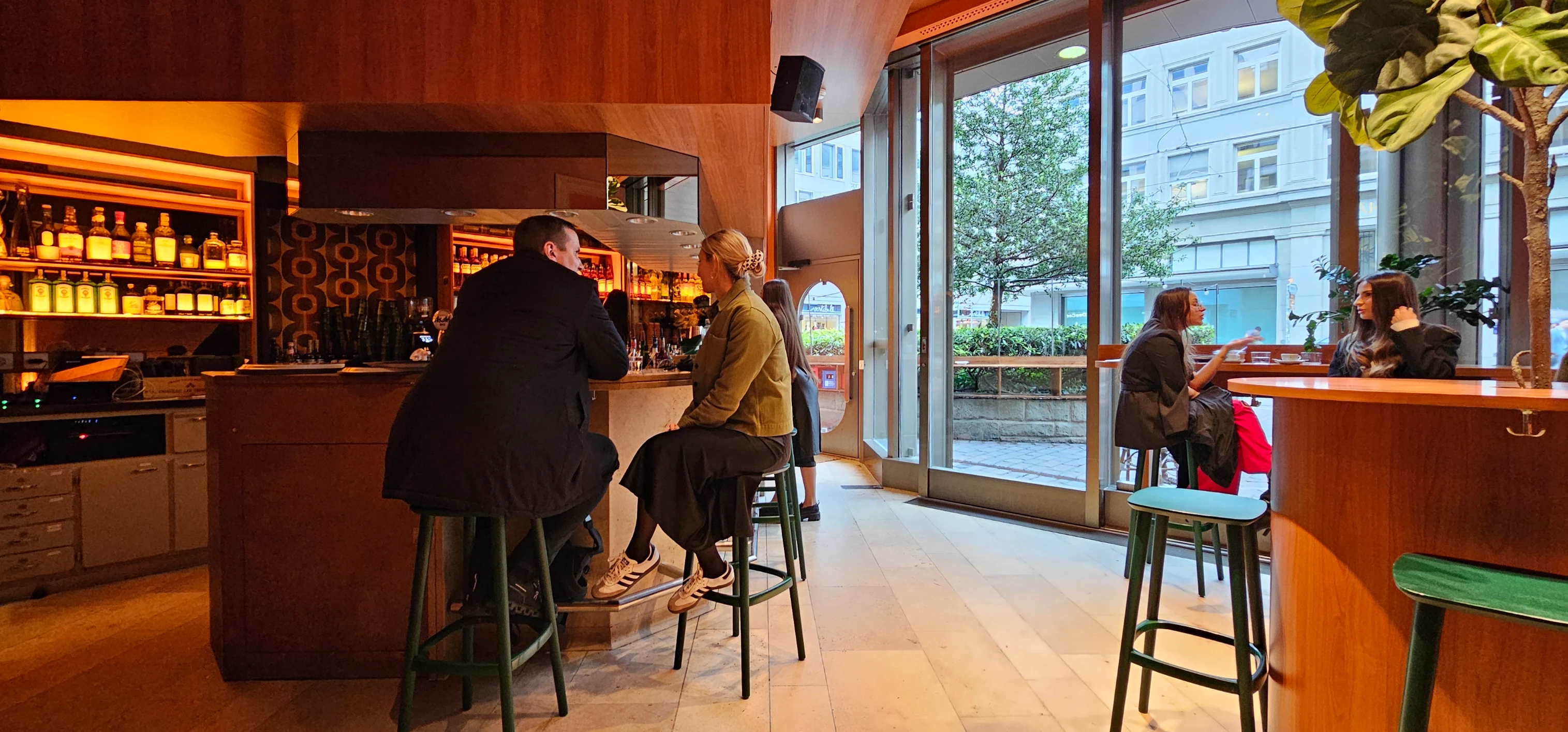 Guests having coffee by the window at Le Café during the day